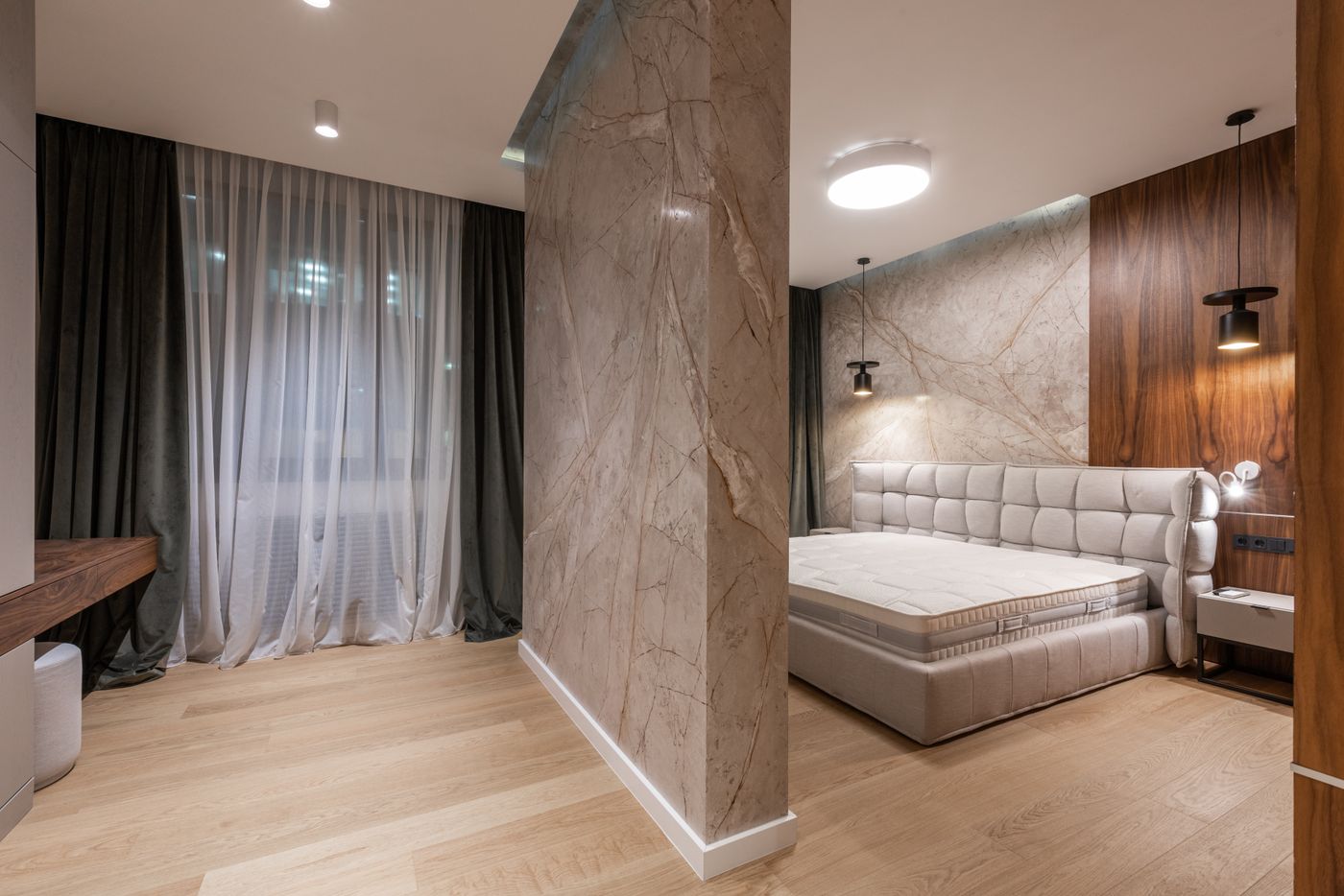 A serene bedroom finished in marble and warm timber