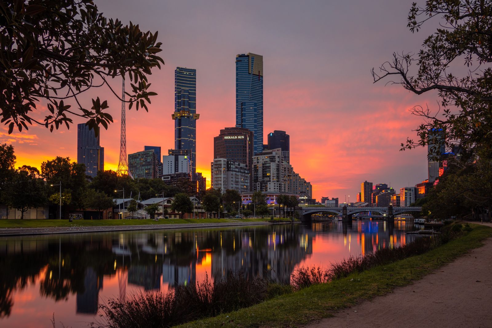 The Melbourne skyline and Eureka Tower reflected in the Yarra River at sunset, seen from the Southbank riverside